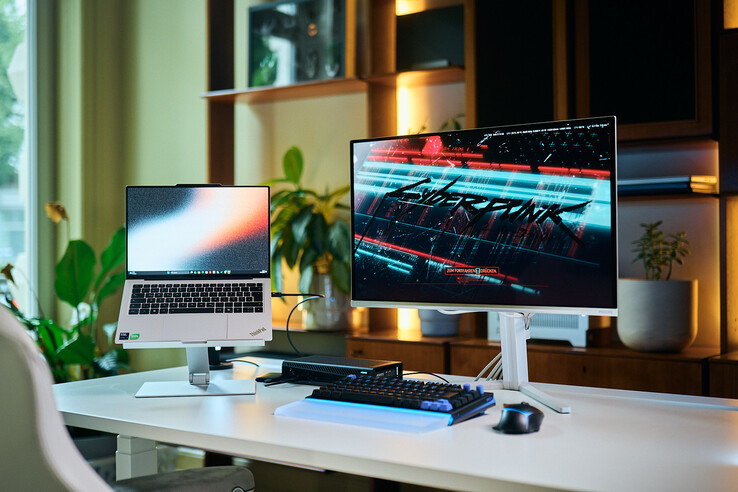 Configuration complète d’un poste de travail comprenant un ordinateur portable ThinkPad X9 14 sur un socle, une carte graphique externe (eGPU) Aorus RTX 5060 Ti AI Box et un écran externe affichant le jeu Cyberpunk 2077.