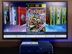 Une Xbox 360 bleue modifiée exécutant un tableau de bord homebrew personnalisé sur un moniteur, affichant le jeu "Conker : Live and Reloaded" ainsi que d'autres titres Xbox et émulateurs. (Source de l'image : Modern Vintage Gamer sur YouTube)