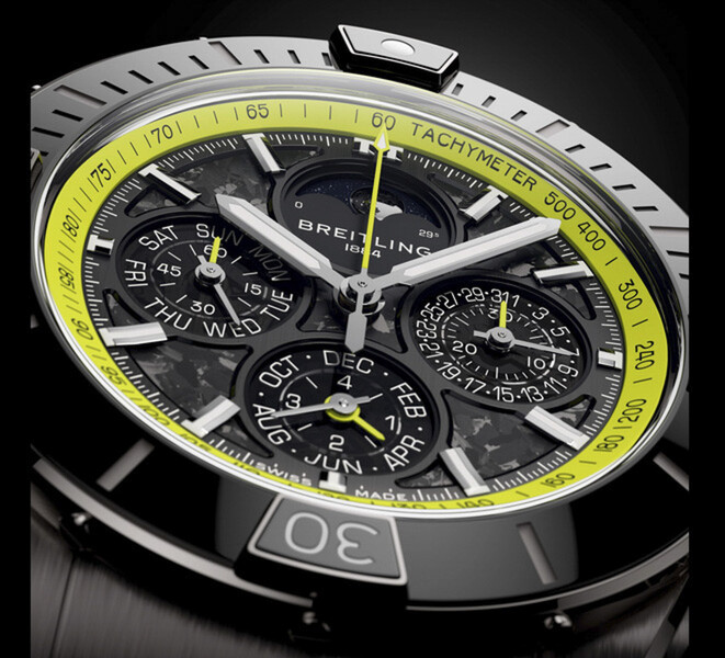 Gros plan du Breitling Super Chronomat B19 44 Perpetual Calendar Chronograph montrant son cadran en fibre de carbone, ses compteurs de calendrier, ses aiguilles argentées et son échelle tachymétrique vert citron.