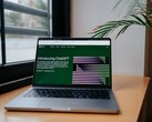 Un ordinateur portable posé sur un bureau près d'une fenêtre, avec le site web OpenAI ChatGPT ouvert à l'écran