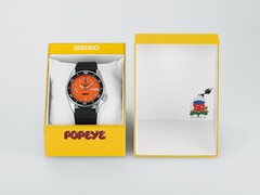 Montre automatique Seiko 5 Sports x Popeye HDB013, dotée d'un cadran orange, posée à côté de son coffret de présentation jaune en édition limitée.