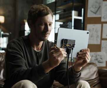 Utilisateur connectant le SSD portable transparent Sharge Disk Pro avec refroidissement actif à une tablette via un câble USB-C. (Sharge via Kickstarter)