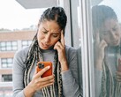 Une femme regarde son smartphone avec un air sérieux