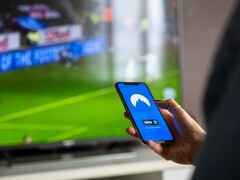 Une main tient un smartphone sur lequel l'application VPN est ouverte