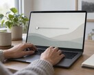 Les mains sur le clavier d'un ordinateur portable, un curseur à l'extrême gauche de l'écran