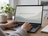 Les mains sur le clavier d'un ordinateur portable, un curseur à l'extrême gauche de l'écran
