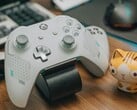 Manette de Xbox blanche posée sur un bureau en bois à côté d'une petite figurine de chat (Image source : FOX ^.ᆽ.^= ∫ via Pexels)