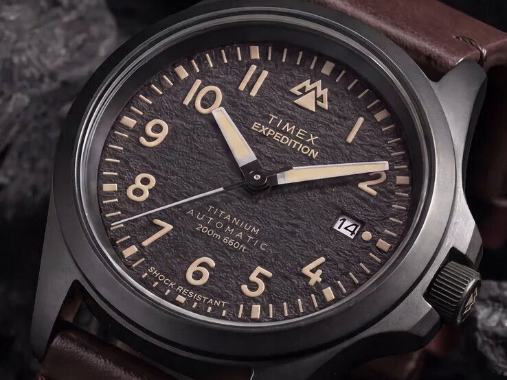 Gros plan sur le cadran noir texturé de la Timex Expedition Field Post Titanium, avec ses chiffres arabes, ses aiguilles et index luminescents, ainsi que son guichet de date.